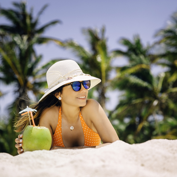코코넛 칵테일을 들고 해변에 있는 여자