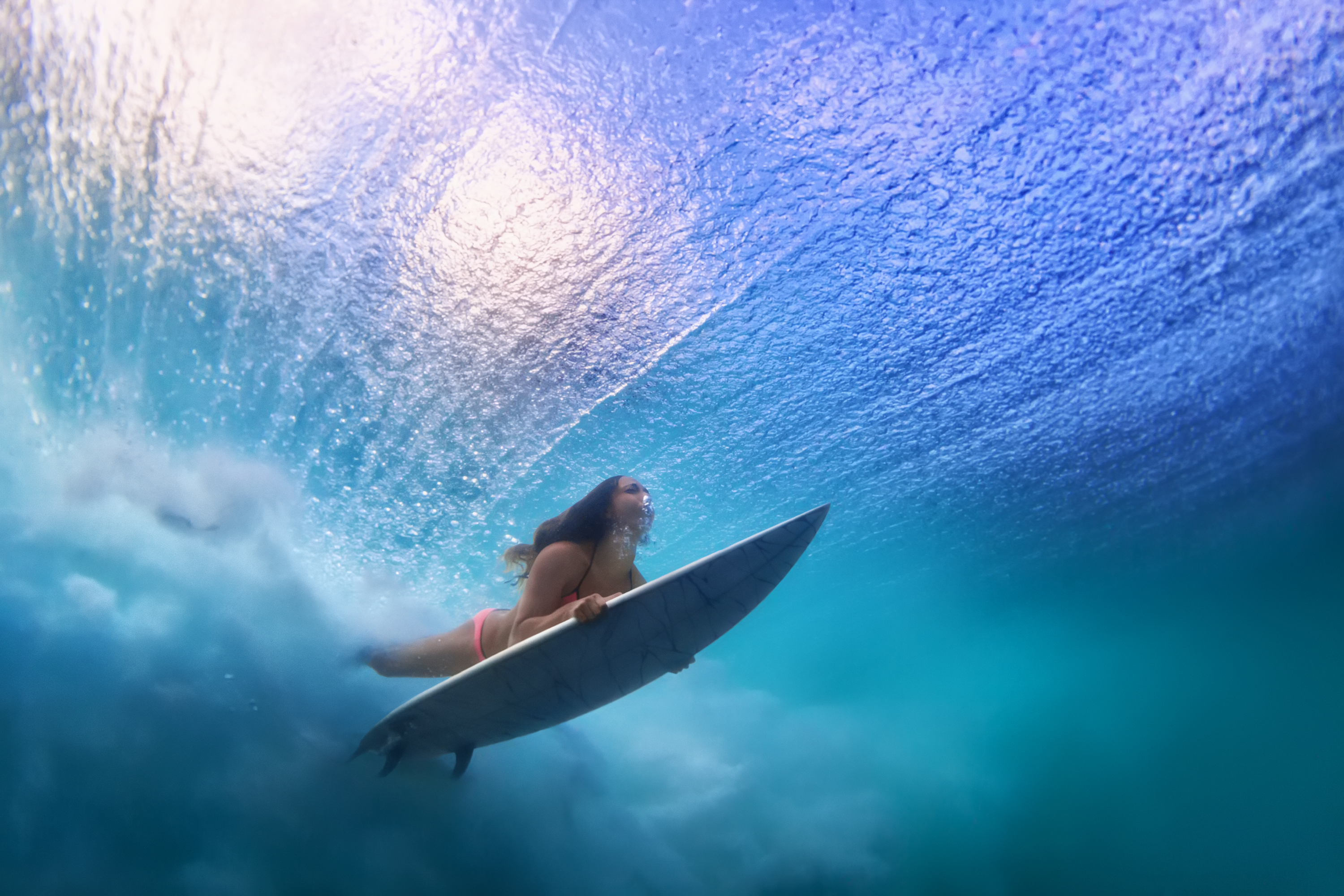 Surfer under a wave